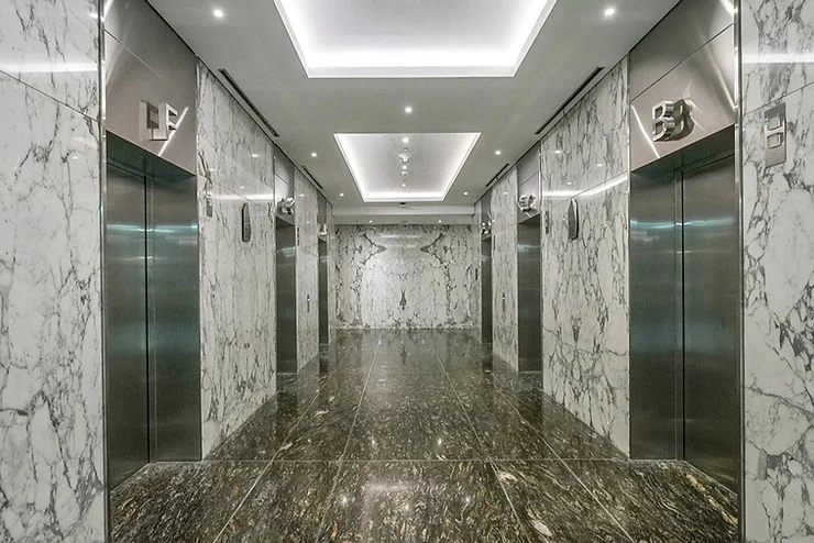 Area elevator dengan dinding menggunakan batu alam seperti marmer di kantor membuat area kantor menjadi lebih nyaman dan bersih.